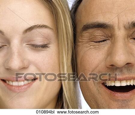 Stock Image - close-up portrait of mature man and young woman smiling and laughing. Fotosearch