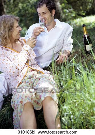 Stock Image - couple having picnic in a park. Fotosearch
