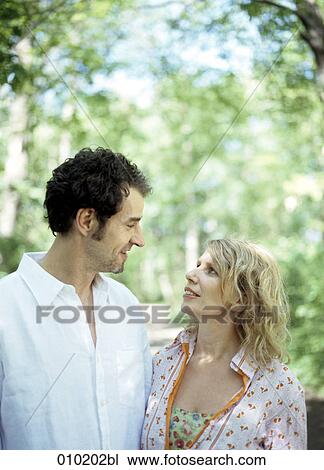 couple in the park smiling at each other View Large Photo Image Stock Image - couple in the park smiling at each other. Fotosearch