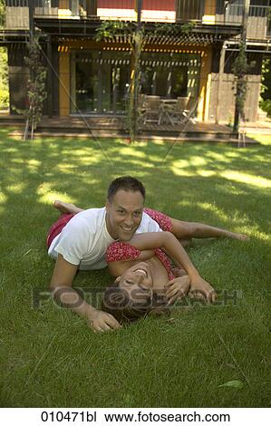 couple lying on grass in front of weekend home View Large Photo Image Stock Image - couple lying on grass in front of weekend home. Fotosearch