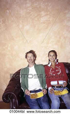 couple on leather sofa with Indian take-away food on their laps, smiling View Large Photo Image Stock Image - couple on leather sofa with Indian take-away food on their laps, smiling. Fotosearch
