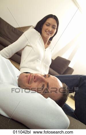 Stock Image - Couple relaxing on the floor of their living room. Fotosearch