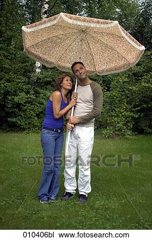 couple seeking shelter from rain under a sunshade View Large Photo Image Stock Image - couple seeking shelter from rain under a sunshade. Fotosearch
