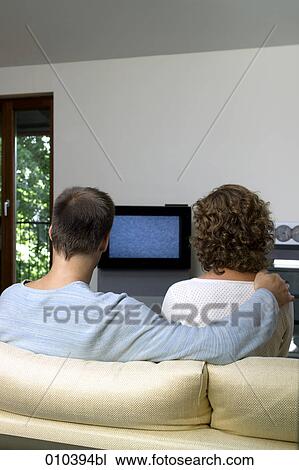 Stock Image - couple sitting in front of TV set. Fotosearch