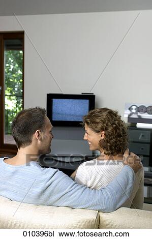 Stock Image - couple sitting in front of TV set. Fotosearch