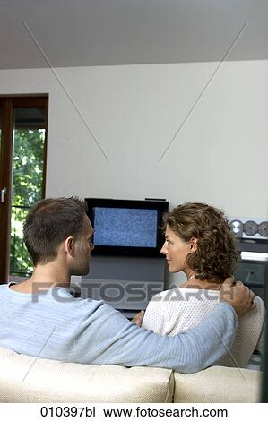 Stock Image - couple sitting in front of TV set. Fotosearch