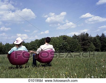 couple sitting in lounge chairs outdoors with back to the viewer View Large Photo Image Stock Image - couple sitting in lounge chairs outdoors with back to the viewer. Fotosearch