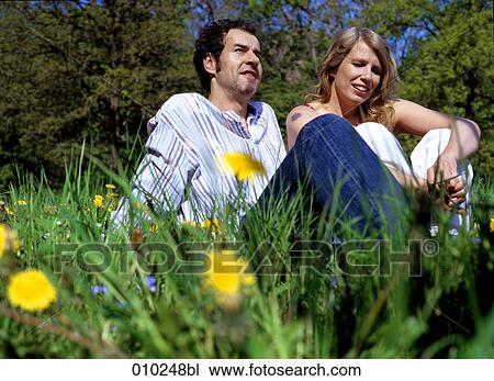 couple sitting in the grass enjoying the sunny weather View Large Photo Image Stock Image - couple sitting in the grass enjoying the sunny weather. Fotosearch