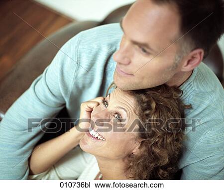 couple sitting together; man having his arms around woman View Large Photo Image Stock Image - couple sitting together; man having his arms around woman. Fotosearch