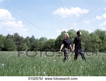 couple walking in the grass View Large Photo Image Stock Image - couple walking in the grass. Fotosearch