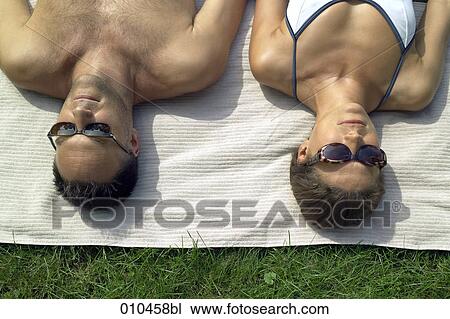 couple with sun glasses sunbathing View Large Photo Image Stock Image - couple with sun glasses sunbathing. Fotosearch