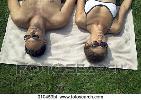 couple with sun glasses sunbathing View Large Photo Image Stock Image - couple with sun glasses sunbathing. Fotosearch