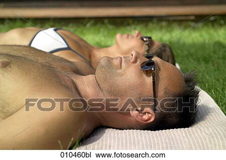 couple with sun glasses sunbathing View Large Photo Image Stock Image - couple with sun glasses sunbathing. Fotosearch