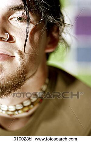 Stock Image - cropped close-up of a young man with nose piercing. Fotosearch