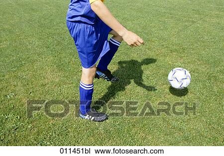 Stock Image - detail of football player kicking the ball. Fotosearch