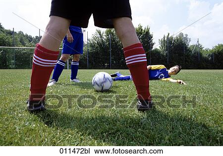 Stock Image - footballer trying to shoot the ball through his opponents legs. Fotosearch