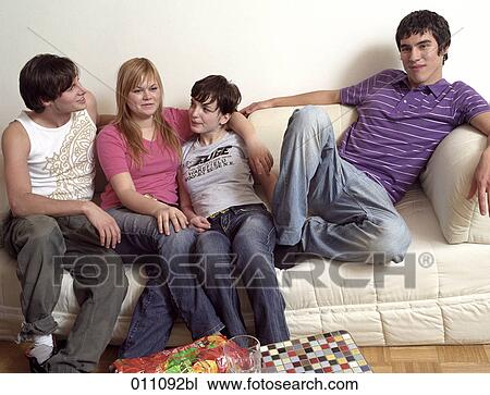 Stock Image - Four friends sitting together one with thoughtful expression. Fotosearch