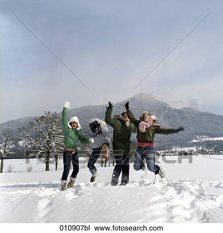 Stock Image - four teenagers playing in the snow. Fotosearch