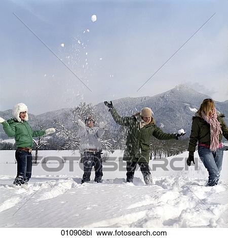 Stock Image - four teenagers playing in the snow. Fotosearch