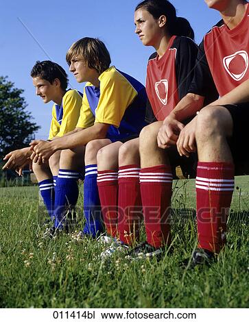 four teenagers sitting on bench watching football game View Large Photo Image Stock Image - four teenagers sitting on bench watching football game. Fotosearch