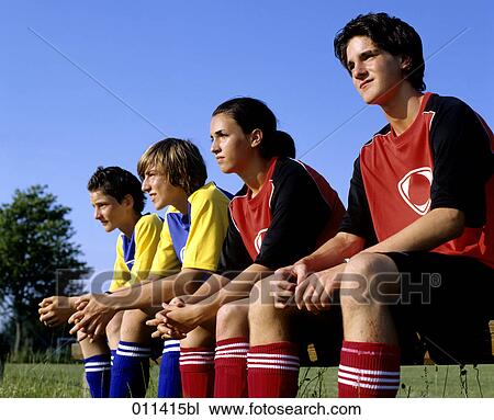Stock Image - four teenagers watching football game. Fotosearch