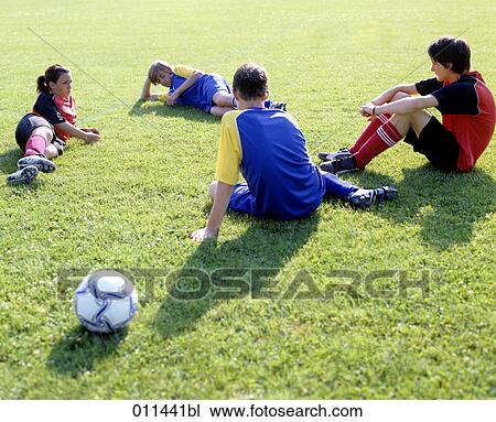 four young football players relaxing in grass View Large Photo Image Stock Image - four young football players relaxing in grass. Fotosearch
