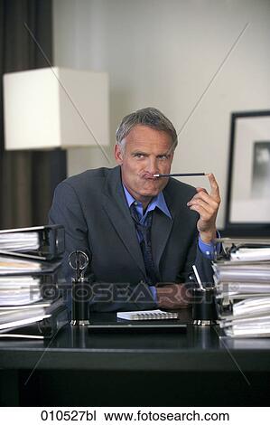 grimacing businessman surrounded by piles of files View Large Photo Image Stock Image - grimacing businessman surrounded by piles of files. Fotosearch