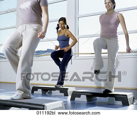 Stock Image - Group doing exercises with core boards in gym. Fotosearch