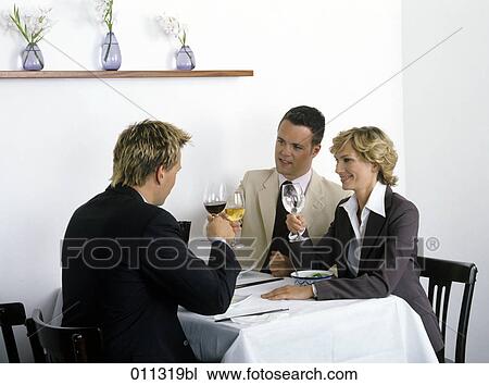 Stock Image - group of businessmen raising their glasses to celebrate. Fotosearch