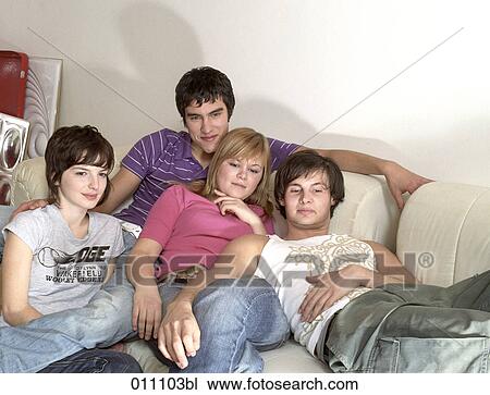 Stock Image - Group of four teenagers watching television. Fotosearch