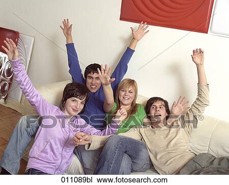 Stock Image - Group of friends raising their arms in joy. Fotosearch