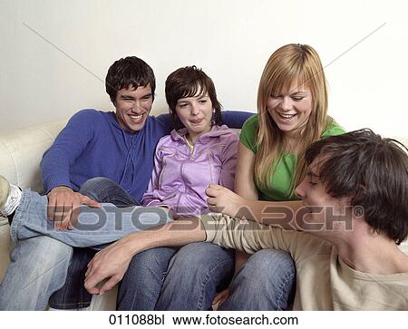 Group of teenage friends having a talk on the sofa View Large Photo Image Stock Image - Group of teenage friends having a talk on the sofa. Fotosearch