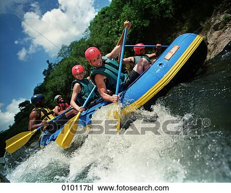 Stock Image - group of young people river rafting. Fotosearch