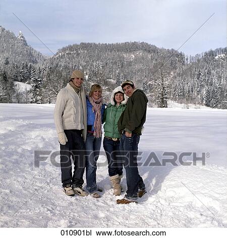 Stock Image - group portrait of four teenagers in the snow. Fotosearch