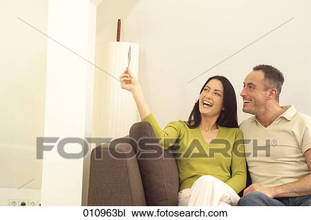 Happy couple looking at a photograph View Large Photo Image Stock Image - Happy couple looking at a photograph. Fotosearch