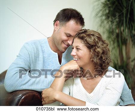 Stock Image - happy couple sitting together. Fotosearch
