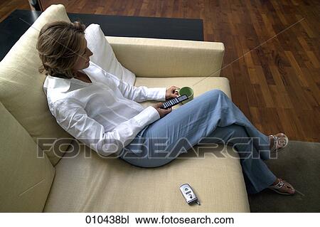 Stock Image - high angle view of woman sitting on sofa. Fotosearch