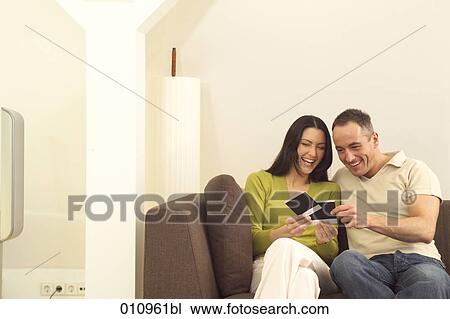 Laughing couple looking at polaroids View Large Photo Image Stock Image - Laughing couple looking at polaroids. Fotosearch