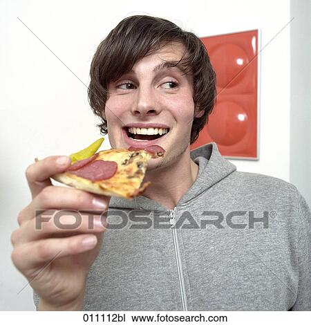Stock Image - Laughing teenager with pizza piece. Fotosearch