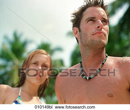 male caucasian on the beach, woman in background View Large Photo Image Stock Image - male caucasian on the beach, woman in background. Fotosearch