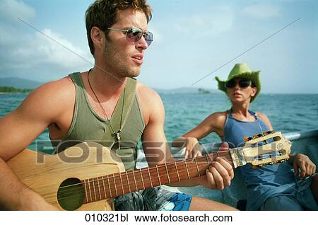 man (30-35 years) playing guitar on a boat View Large Photo Image Stock Image - man (30-35 years) playing guitar on a boat. Fotosearch