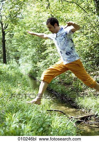 man (35-40 years) jumping over brook in the woods (blurred image! ) View Large Photo Image Stock Image - man (35-40 years) jumping over brook in the woods (blurred image! ). Fotosearch