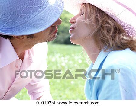 Stock Image - man and woman kissing each other. Fotosearch