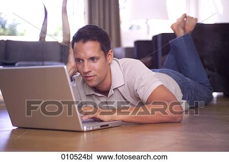 man at home lying on the floor and working with notebook View Large Photo Image Stock Image - man at home lying on the floor and working with notebook. Fotosearch
