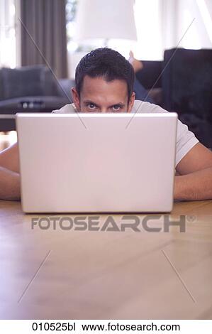 man at home lying on the floor, glancing over notebook View Large Photo Image Stock Image - man at home lying on the floor, glancing over notebook. Fotosearch
