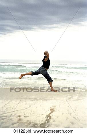 Stock Image - man doing a jump at the seaside. Fotosearch