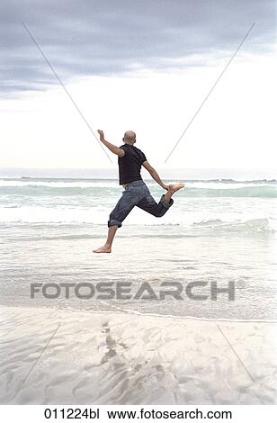 man jumping on the beach View Large Photo Image Stock Image - man jumping on the beach. Fotosearch