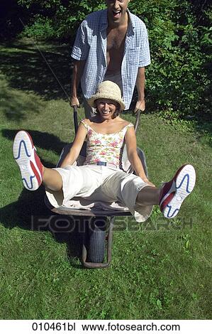 man pushing his woman in a wheelbarrow View Large Photo Image Stock Image - man pushing his woman in a wheelbarrow. Fotosearch