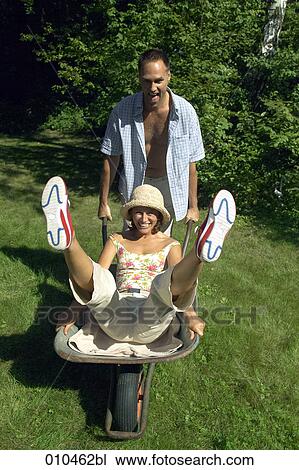 man pushing his woman in a wheelbarrow View Large Photo Image Stock Image - man pushing his woman in a wheelbarrow. Fotosearch