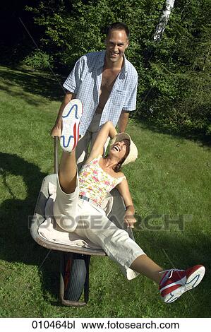 man pushing his woman in a wheelbarrow View Large Photo Image Stock Image - man pushing his woman in a wheelbarrow. Fotosearch